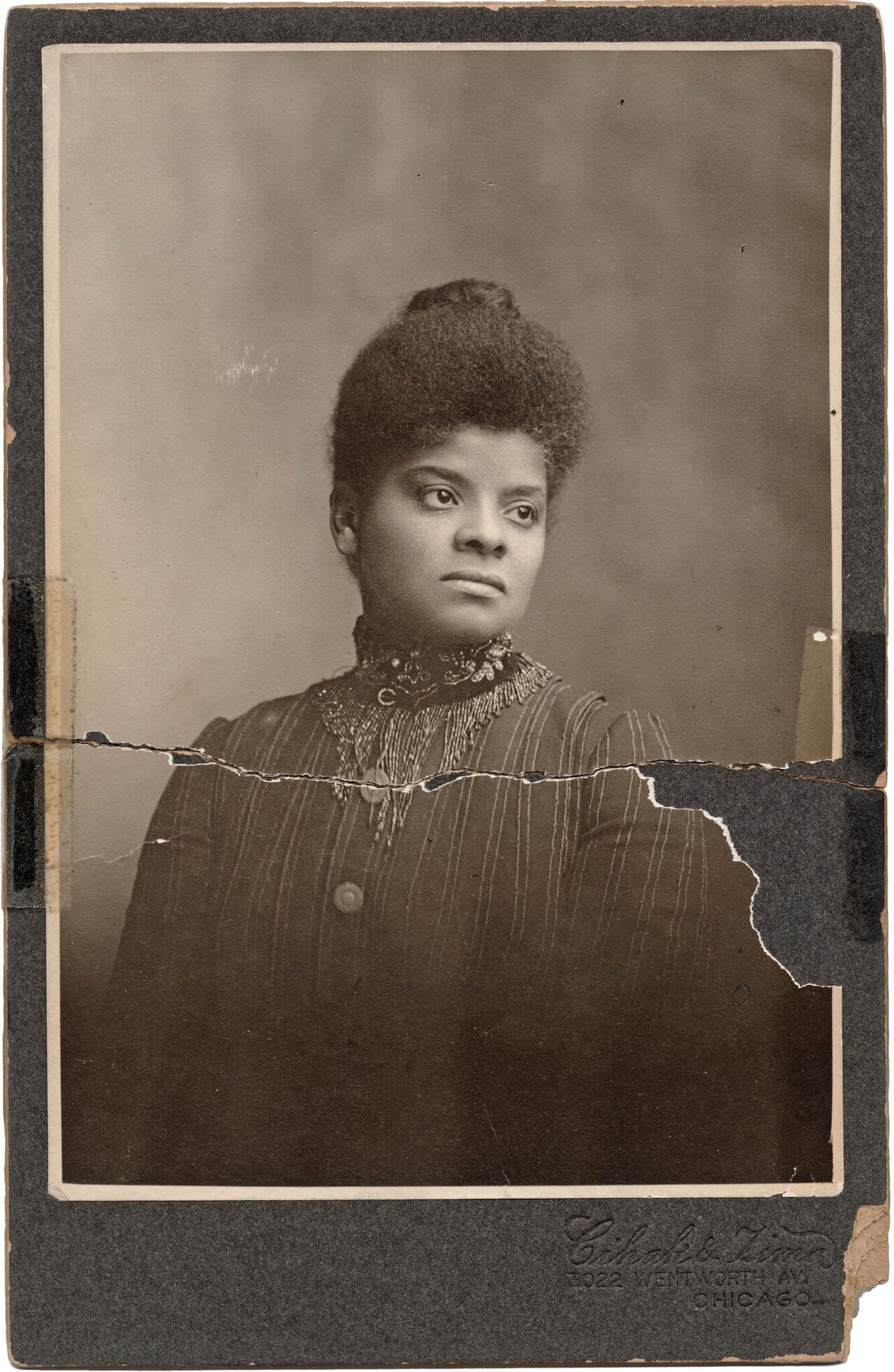 Sepia cabinet-card portrait of Ida B. Wells, circa 1895, by Cihak and Zima of Chicago. The photograph is torn across the middle and mended with tape.